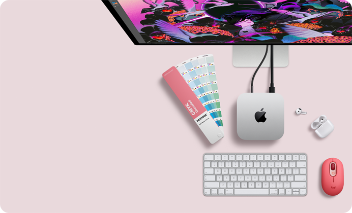 Mac mini, Oberseite, Aluminium Silber, gerundete Ecken, glänzendes schwarzes Apple Logo in der Mitte, verbunden über ein Kabel, Studio Display oben teilweise sichtbar, AirPods 4, geöffnet, Pantone Farbpaletten, Logitech Tastatur und Maus in Rot